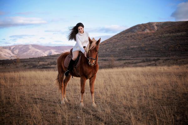 Beautiful woman on a horse riding tour