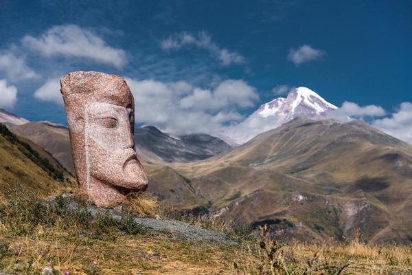 Rustaveli Stone Sculpture on Kazbek Mount Background