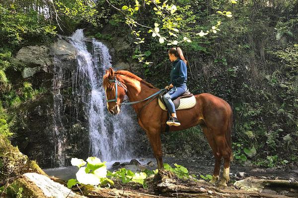 Horse Riding Near a Waterfall