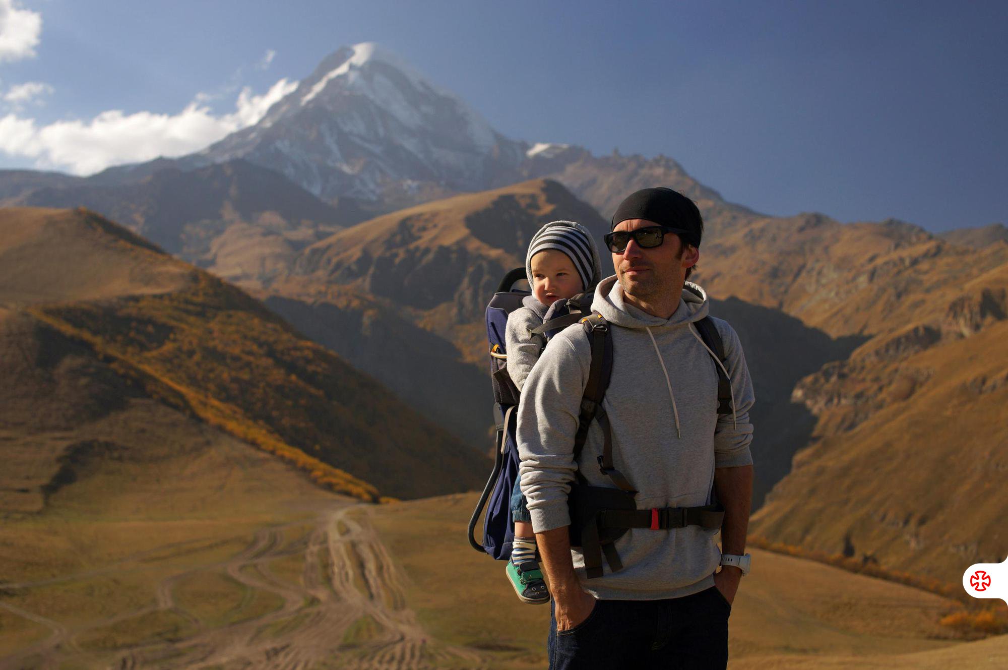 Father with his child in front of Mount Kazbek summit.